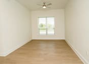 Thumbnail 11 of 28 - Empty room with a window and a ceiling fan.