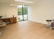 Thumbnail 26 of 28 - A room with a purple chair and wooden floors.