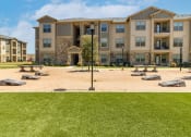 Thumbnail 19 of 23 - a picnic area with benches and a lamppost in front of an apartment building