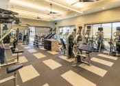 Thumbnail 16 of 23 - a spacious fitness center with cardio machines and other exercise equipment