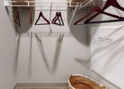 Thumbnail 9 of 23 - a walk in closet with a white closet organizer and a basket on the floor