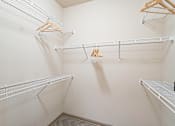 Thumbnail 29 of 35 - A walk-in closet with three shelves and hangers.