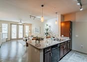 Thumbnail 23 of 35 - A kitchen with a large island and pendant lights.