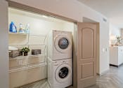 Thumbnail 35 of 35 - A white washing machine is in a laundry room.