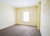 Thumbnail 7 of 16 - A room with a carpeted floor and a window.