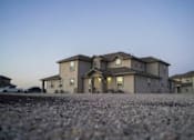 Thumbnail 1 of 16 - A large house with a driveway in front of it.