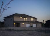 Thumbnail 14 of 16 - A house with a garage and a driveway in front.