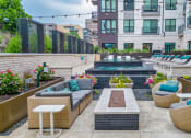 Thumbnail 28 of 41 - a patio with couches and chairs and a pool in the middle of a building
