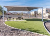 Thumbnail 18 of 46 - a park with picnic tables under a canopy