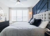 Thumbnail 22 of 33 - a bedroom with a large bed with pillows and a black and white accent wall