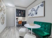 Thumbnail 16 of 33 - a living room with a green couch and a white table