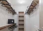 Thumbnail 24 of 33 - a walk in closet with a shoe rack on the wall and a closet with shelves