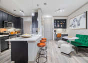 Thumbnail 15 of 33 - a kitchen and living room with an island and stools