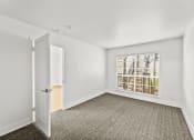 Thumbnail 4 of 24 - an empty bedroom with a large window and a door to a closet
