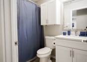 Thumbnail 11 of 33 - a bathroom with a blue shower curtain and a toilet