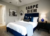Thumbnail 9 of 33 - a bedroom with a bed with a white comforter and blue pillows