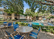 Thumbnail 22 of 22 - A patio with a table and chairs overlooking a pool.