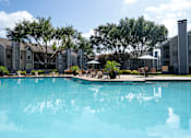 Thumbnail 53 of 68 - A large swimming pool in front of apartment buildings.