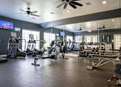 Thumbnail 54 of 68 - A gym with a variety of equipment including treadmills, weights, and exercise machines.
