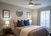 Thumbnail 55 of 68 - A bedroom with a large bed and a ceiling fan.