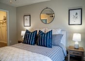 Thumbnail 65 of 68 - A bedroom with a bed, two lamps, and two framed pictures on the wall.