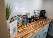 Thumbnail 61 of 68 - A wooden countertop with a sign that says Chelsea and a coffee maker on it.