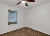 Thumbnail 12 of 23 - a bedroom with a ceiling fan and a window