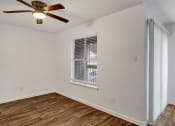 Thumbnail 4 of 23 - a bedroom with hardwood floors and a ceiling fan