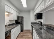 Thumbnail 8 of 23 - a kitchen with white cabinets and black countertops