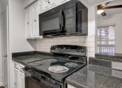 Thumbnail 10 of 23 - a kitchen with a stove top oven next to a microwave