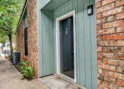 Thumbnail 2 of 23 - a green door with a white frame on a brick building