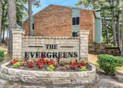 Thumbnail 1 of 23 - a stone sign that says the evergreens in front of a brick building