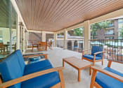 Thumbnail 34 of 44 - a covered patio with blue chairs and a coffee table