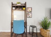 Thumbnail 4 of 44 - a desk with a blue chair and a black stool in a room with a white wall and