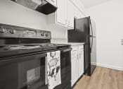 Thumbnail 8 of 44 - a kitchen with white cabinets and black appliances