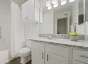 Thumbnail 15 of 44 - a bathroom with white cabinets and a white bathtub