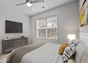 Thumbnail 4 of 17 - A bedroom with a bed, dresser, and a television.