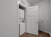 Thumbnail 6 of 17 - A white door is open to a small bathroom.