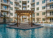 Thumbnail 32 of 32 - A wooden pergola is situated in the middle of a pool.