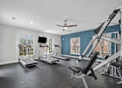 Thumbnail 16 of 26 - A spacious home gym with treadmills, a stationary bike, and a weight bench.