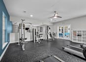Thumbnail 18 of 26 - A spacious home gym with a variety of equipment including a treadmill, weights, and a bench press.