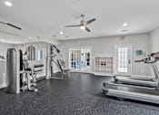 Thumbnail 17 of 26 - A spacious gym with a variety of equipment including treadmills, weights, and a bench press.