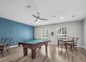 Thumbnail 23 of 26 - A pool table is in the middle of a room with a ceiling fan.