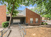 Thumbnail 26 of 26 - A brick building with a metal roof and a tree in front.