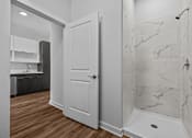 Thumbnail 6 of 42 - A white door is in a bathroom with marble tiles.