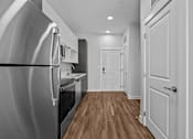 Thumbnail 15 of 42 - A modern kitchen with a refrigerator on the left and a wooden floor.