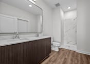 Thumbnail 26 of 42 - A bathroom with a wooden vanity and a marble shower.