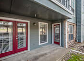 Thumbnail 13 of 26 - A house with red doors and a grey wall.