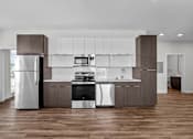 Thumbnail 9 of 42 - A modern kitchen with a refrigerator, stove, and oven.