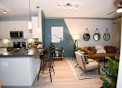 Thumbnail 3 of 28 - A modern kitchen with a bar stool and a chair.